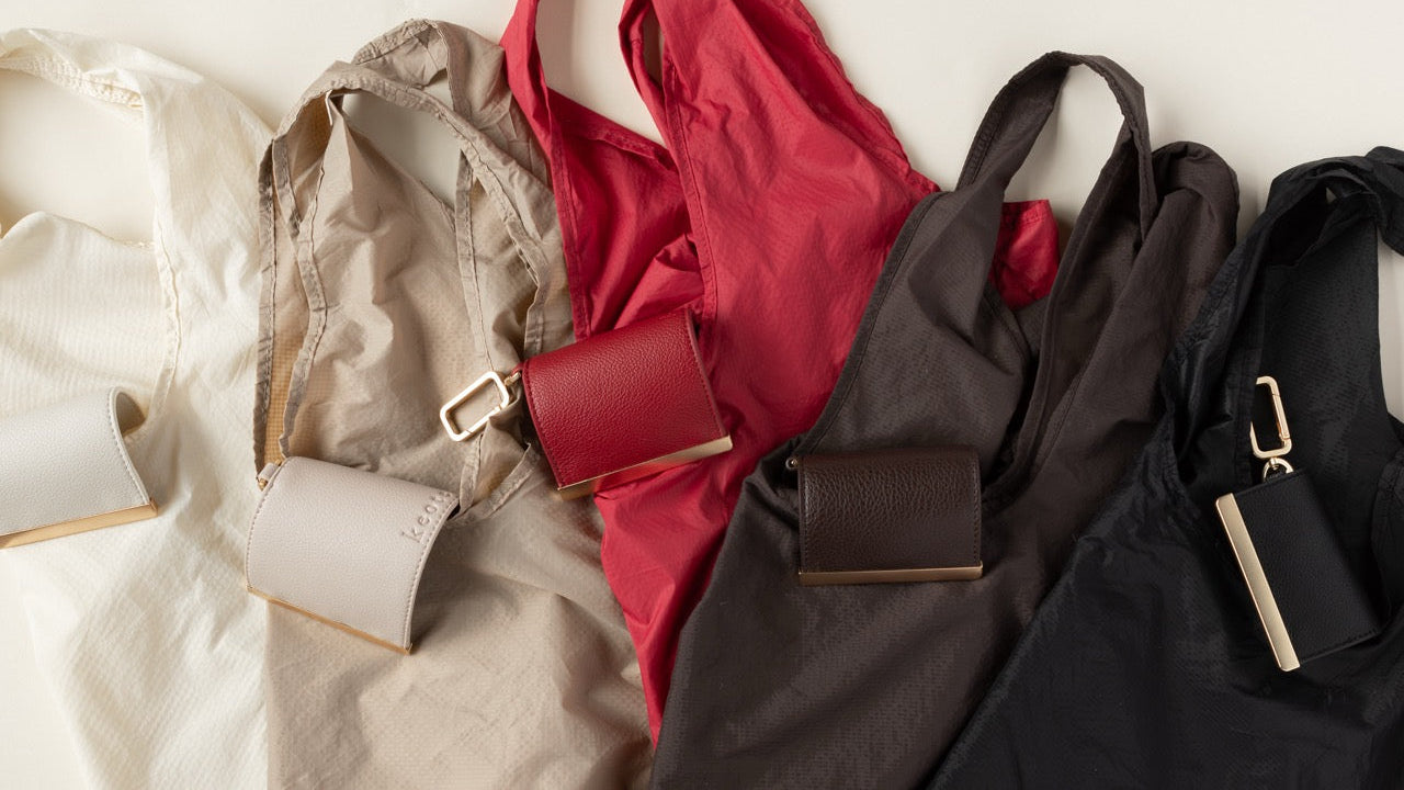 Collection of handbags in various colors on a light background